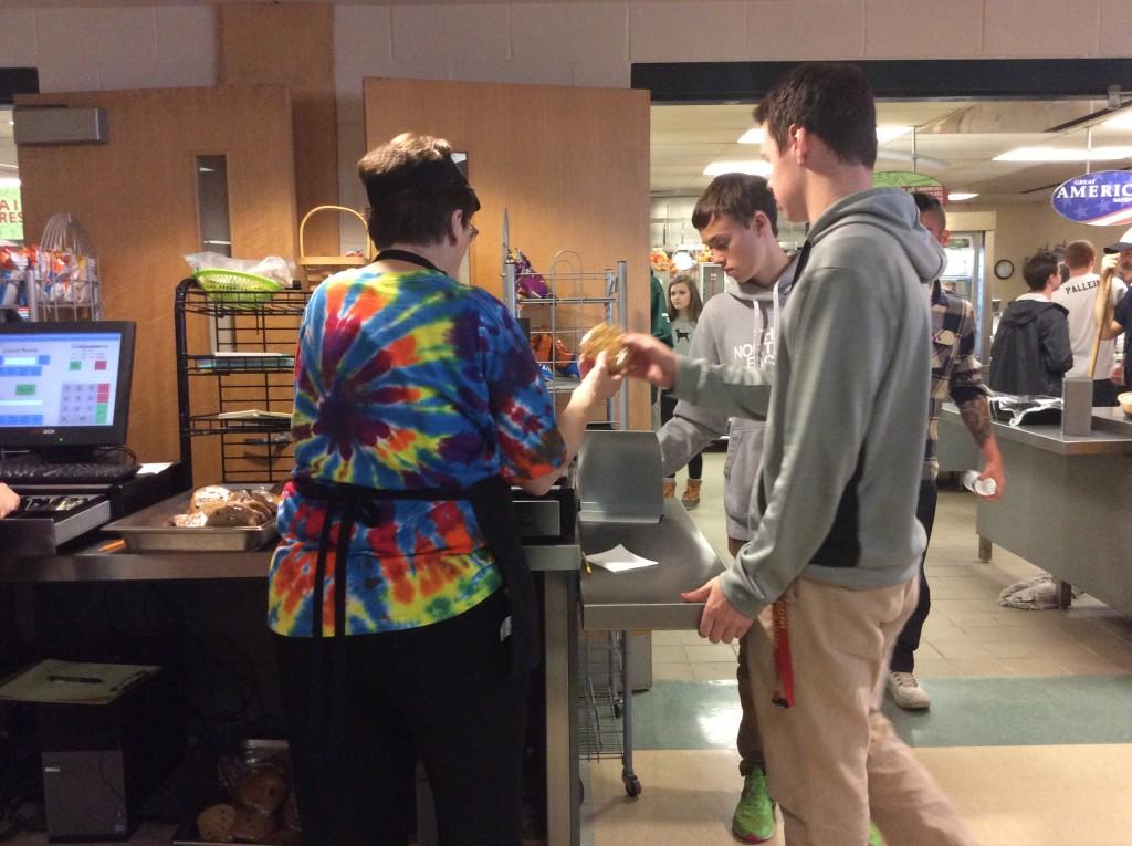 Kathy Bieri sells a cookie to senior Jack Marcou during lunch.