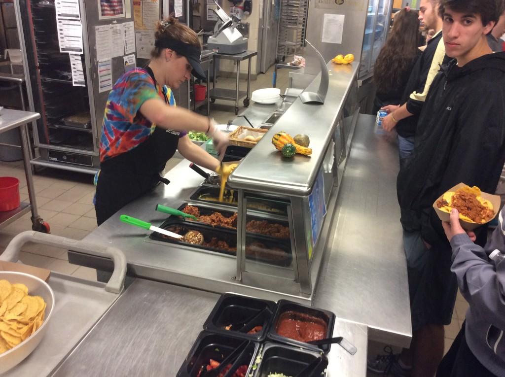 Laura Chatten scoops melted cheese over nachos as the lunch rush enters the cafeteria.