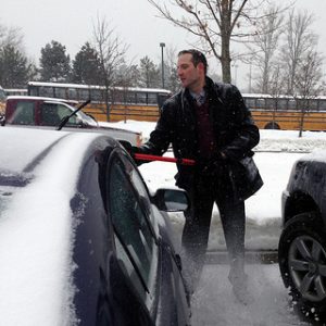 Principal Bishop helps clear staff cars on 2/13/14. (hhspress photo)