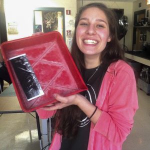 Photo Club Member Nina Augustini excitedly shows off a test strip of one her film prints in the making  Photo by: Jill Sullivan