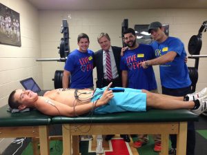 Junior Sam Cestari gets ECG at Hopkinton High School last Friday September 25. Behind: left, Jack Nealon (Co-founder of Live4Evan), Dr. Jack Cadigan (cardiologist at Boston Medical Center), Patrick Cusanelli (Live4Evan representative), Evan Ernst (Founder of Who.We.Play.For) Photo by: Julia Joshi