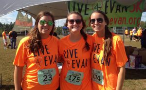 Anna Valle, Elle Girardi, and Maddie Girardi relaxing on the field after the race. Photo by Juliette Davis.