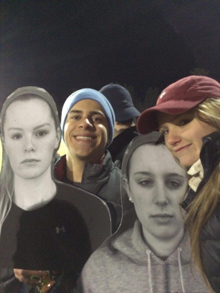 Hopkinton High School seniors Joseph Lanen and Christine Leonard cheer on their classmates at the powderpuff game under the lights. Photo by Alli McNulty.