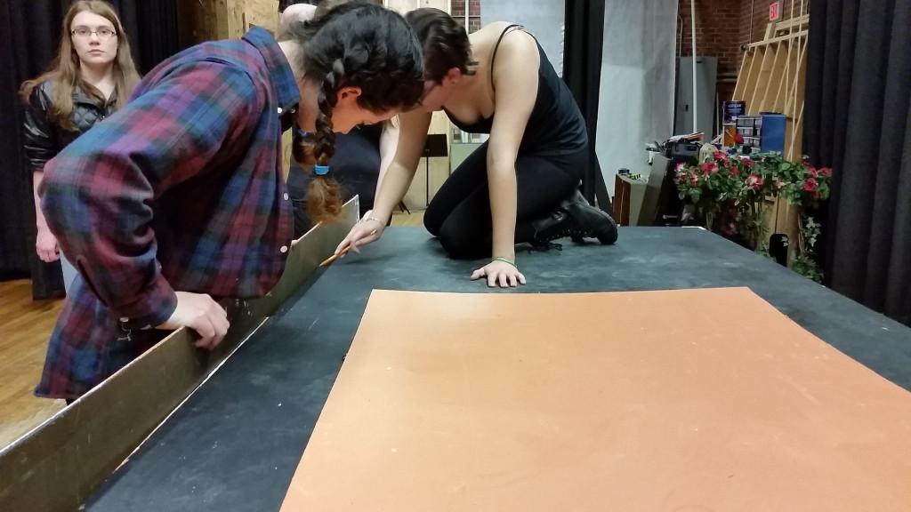 Stage manager McKenzie Simmons and crew member Meg Bradbury preparing to put together set piece.