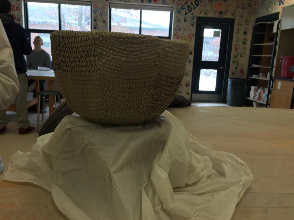 Ceramics II student, senior Jill Kellett, uses texture on her newest project. Photo by Emma Zack.