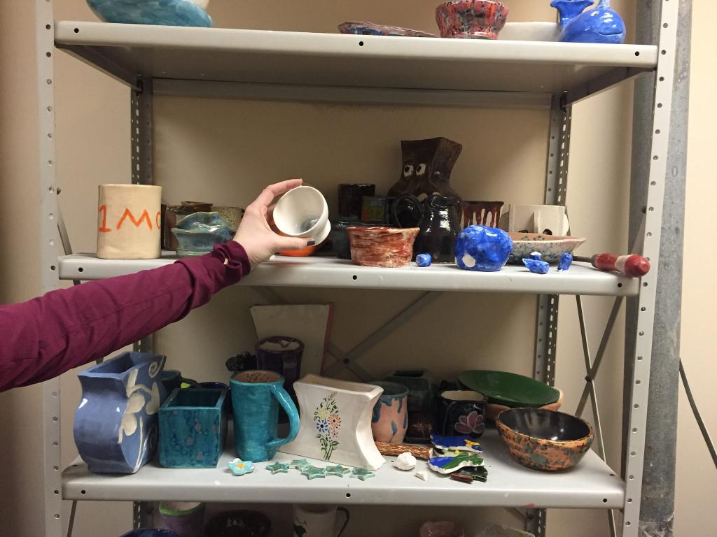 Senior Kayla Patrick picks up her finished project from the shelf and is ready to take it home. Photo by Casey Palmer.