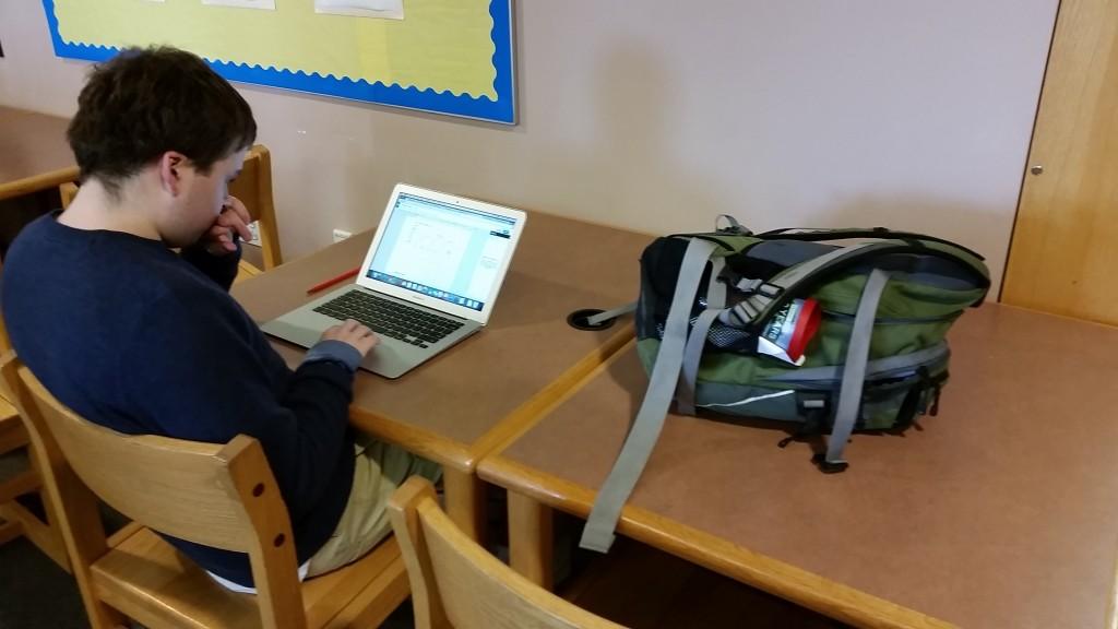 Senior Trevor Perkins using his laptop to study for his government midterm during a free period in the library.