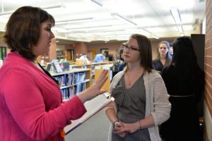 A science fair judge speaks with sophomore Freya Proudman about her project at the 2016 HHS Science Fair, held Mar. 1 in the library. Photo courtesy of Fred Haas.