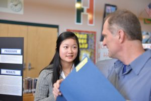 Sophomore Callie Gu discusses her project with a judge at the 2016 HHS Science Fair. Photo courtesy of Fred Haas.