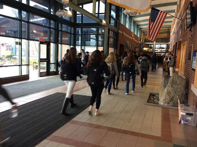 Students strolling into the high school after arriving by school bus or car. Photo by Sarah Fromer.